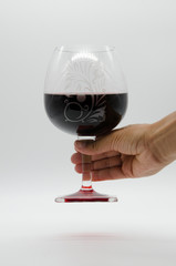 wine glass hold by hand with grapes