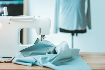 Clothes fabric. Close up of sewing machine that being on table while tailoring dress