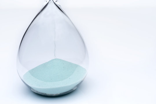 Hourglass on white background. Sand falls inside the flask.