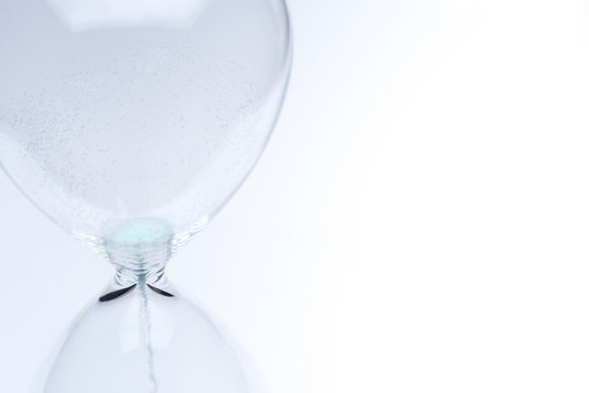 Hourglass on white background. Sand falls inside the flask.