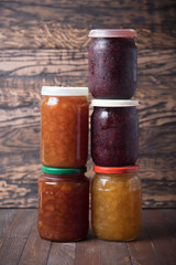 Jars with jam on a brown wooden background