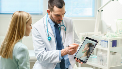 Plastic / Cosmetic Surgeon Consults Woman about Facial Lift Surgery, He Draws Arrows on Digital Tablet Computer Screen, Showing Types of Facelift, Forehead Correcting Procedures Available for Her.