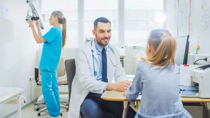 Little Girl Visits Doctor's Office. Friendly Pediartrist Talks with Smart Little Girl. Child Health Examination.