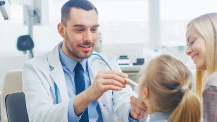 Friendly Doctor Checks up Little Girl's Sore Throat, Mother is Present for Support. Modern Medical Health Care, Friendly Pediatrician and Bright Office.