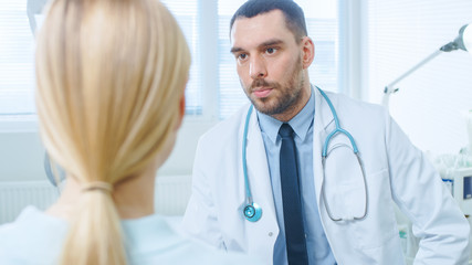 Fototapeta premium Over the Shoulder Shot of a Female Patient Listening to a Medical Doctor.
