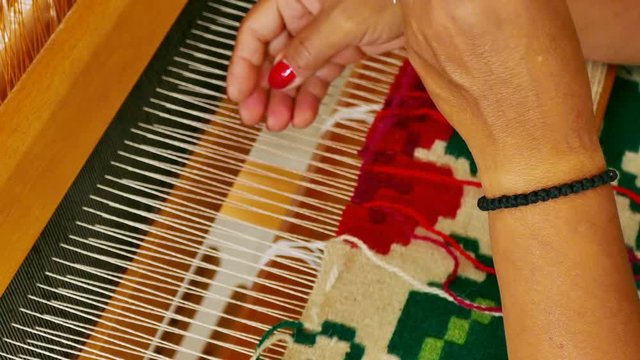 Woman weaving a rug on a wooden loom, 4k Video Clip