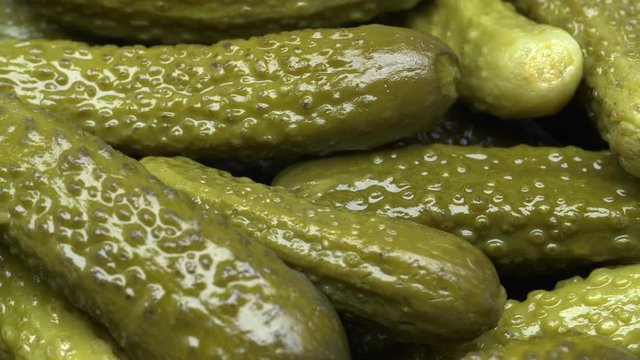 UHD closeup of the pickled cucumbers, cornichons or gherkins on a turntable
