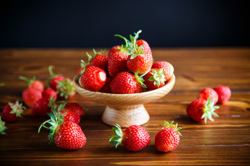 ripe red organic strawberry on a wooden table