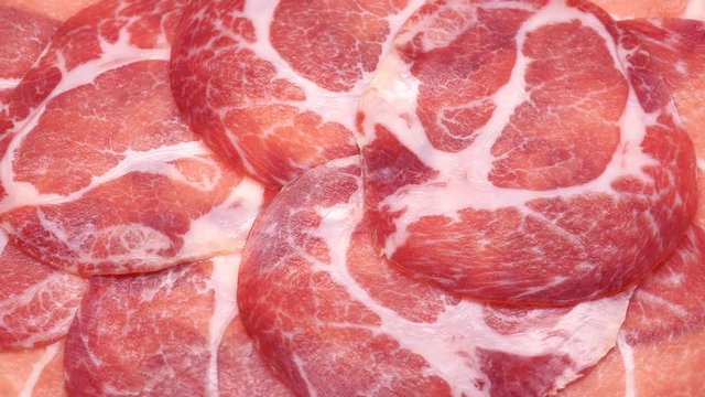 UHD closeup shot of the delicious thin sliced Coppa or Capicola ham on a turntable