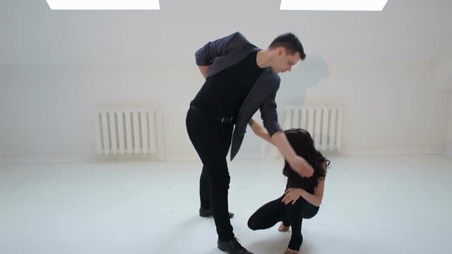 Dancing young couple on a white background. Passionate salsa dancers. Young couple dancing the salsa or bachata at the dance hall.