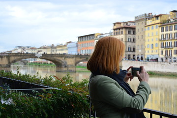 Fototapeta na wymiar Girl taking pictures of the sights of Florence