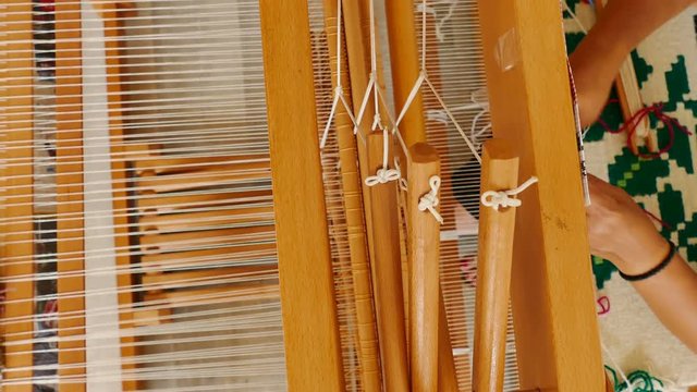Woman weaving a rug on a wooden loom, 4k Video Clip