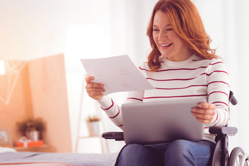 Ideas for start up. Cheerful disabled attractive woman smiling and using laptop