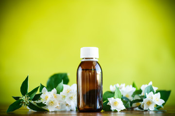 Obraz na płótnie Canvas Essential aroma oil with jasmine on a green