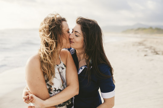 Young couple in love kissing on the deserted beach on a summer evening