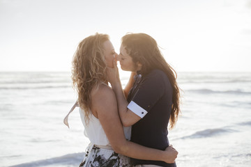 Young couple in love kissing on the deserted beach on a summer evening