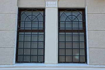 two brown windows with a lattice on a gray concrete wall