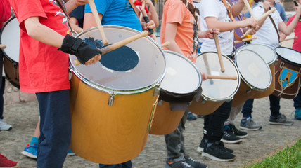 Boys practice playing the drum in the street