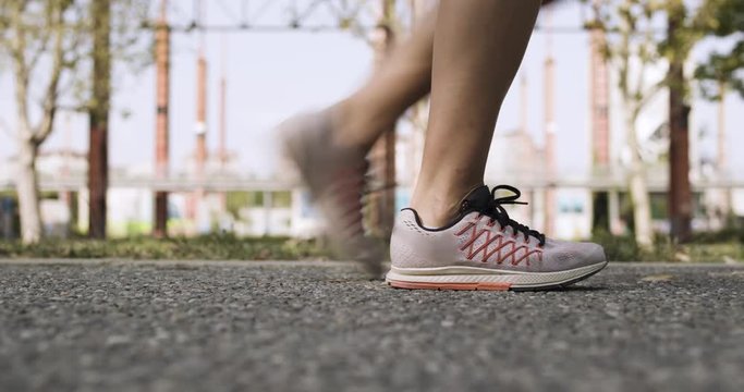 Young blond woman feets view starting running training.Summer sunny day.Industrial green city.Urban runner cardio healthy activity workout.4k slow motion 60p video