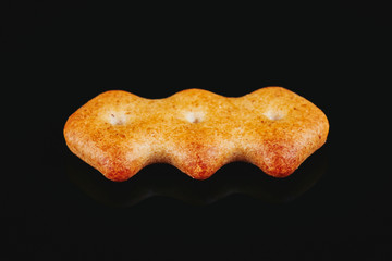 one cookie on a black background