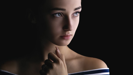 portrait of a beautiful sensual girl with makeup on a black background, woman face