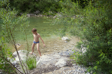 Fototapeta na wymiar Boy getting out of the river