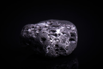 Black porous basalt stone on a black background