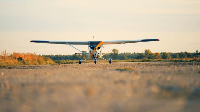 Small airplane with propeller engines goes on a runway. 4K.