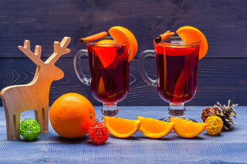 Mulled wine or hot beverage with cinnamon sticks, orange fruit and fir cone. Winter beverage...