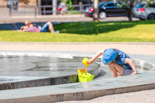 Child playing in a city fountain