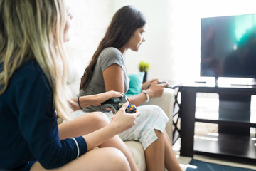 Woman Using With Videogame Console At Friend's Home