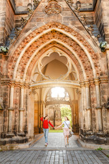 Two girls tourists friends hugging against the background of St. Peter's Church in Leipzig