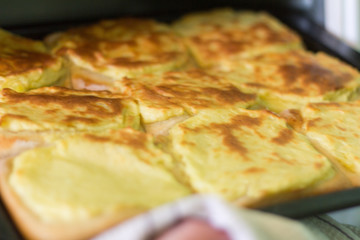 freshly baked cheesecakes with potatoes on a baking sheet, with a small depth of field