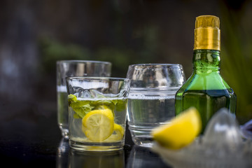 Mojito drink in a transparent glass on wooden surface with white rum,soda,lemon juice,fresh mint leaves,ice cubes and sugar,Close up shot or top shot.