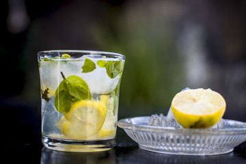 Mojito drink in a transparent glass on wooden surface with white rum,soda,lemon juice,fresh mint...