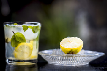 Mojito drink in a transparent glass on wooden surface with white rum,soda,lemon juice,fresh mint leaves,ice cubes and sugar,Close up shot or top shot.