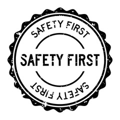 Grunge black safety first word round rubber seal stamp on white background