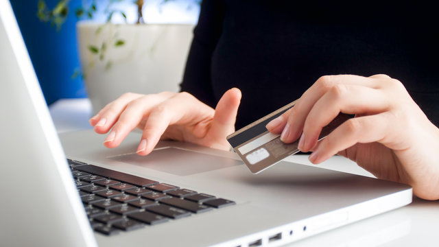 Closeup image of businesswoman using credit card to pay online