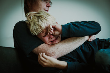 father comforting stressed crying sad son, parenting