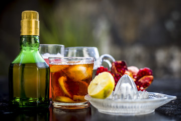 Pamosa or pomosa drink or classic mimosa drink in a transparent glass with champagne,pomegranate juice or annar ka juice,lemon juice,mint leaves,ice cubes and raw pomegranate and lemon,Close up view,