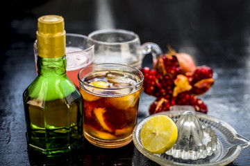 Pamosa or pomosa drink or classic mimosa drink in a transparent glass with champagne,pomegranate juice or annar ka juice,lemon juice,mint leaves,ice cubes and raw pomegranate and lemon,Close up view,