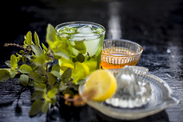 Close up of Herabal drink or Basil lemonade  in a transparent glass  with raw basil,raw honey,ice...