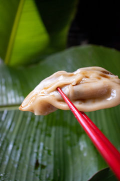 Steamed Steamed Pot Sticker Dumpling In Red Chop Sticks Over Green Banana Leaves