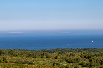 scenic view of Maine coastline with sailboats far off in the distance