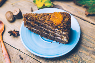 Carrot cake (homemade desserts) whith cinnamon sticks and decorated with spices on wooden background.
