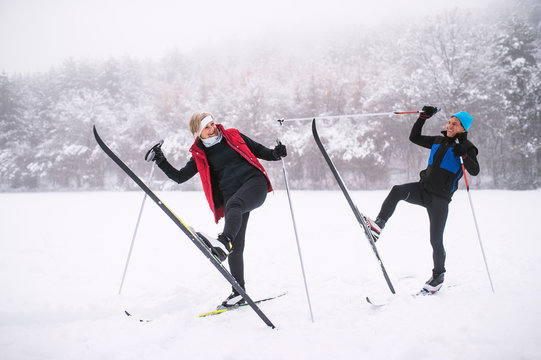 A senior couple cross-country skiing in winter.