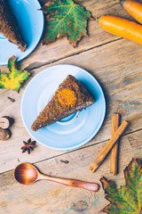 Carrot cake (homemade desserts) whith cinnamon sticks and decorated with spices on wooden background.