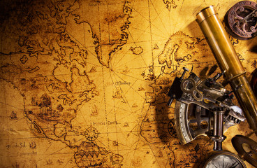 Old vintage navigation equipment on old world map.