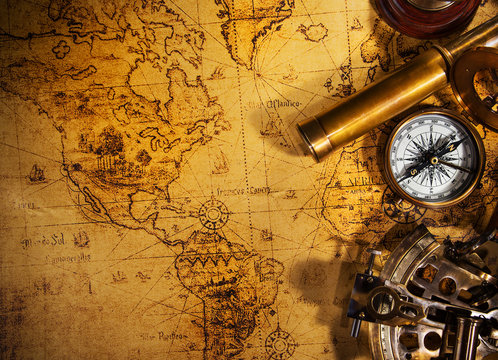 Old vintage navigation equipment on old world map.