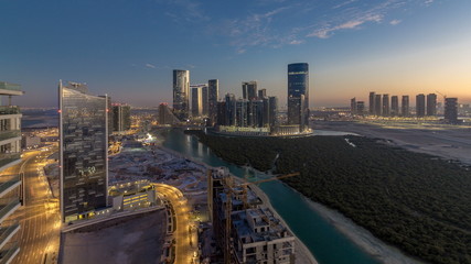 Buildings on Al Reem island in Abu Dhabi day to night timelapse from above. - obrazy, fototapety, plakaty